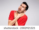 Small photo of Breathless Asian young man in red t shirt hold himself for the neck Isolated on white light gray background. Negative human emotion facial expression