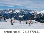 Small photo of Ski resort in the Dolomites. Alpine skiers ski on the ski slopes. Ski slopes in the Dolomites. Alpine skiing sport and recreation. Group of people skiing and snowboarding down the slope.