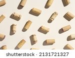 Pattern with wine corks from white and red wine on beige pastel color background with hard light and shadow at sunlight. Trend layout with bottle cap wooden cork, top view, minimal flat lay
