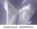 Small photo of Sunlight background, abstract backdrop with light and shadow, glare and shine on paper texture, rainbow sun flare, blue violet color aesthetic image. Natural beams light, caustics effect, top view