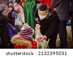 Small photo of Korczowa, Poland 5.03.2022 - a Jew offers sweets to a child fleeing the war from Ukraine