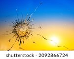 War threat concept. Hole in the glass from a bullet on the background of the flag of Ukraine