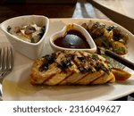 Small photo of Salmon steak. A salmon cut straight through the side of the fish crosswise, grilled and served with barbecue sauce, herbs, sauteed potatoes, and creamy spinach