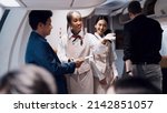Small photo of Cheerful black fight attendant and cabin crew assistant checking travel tickets and informing seat to passengers before departure taking care of passengers on airplane working with service mind
