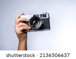 hand holds vintage SLR camera isolated on white background