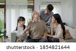 Small photo of Asian elderly senior male grandpa sitting at sofa couch at home living room on quarantine in concept healthcare, chronic health issue or low back pain in retired older people with family.