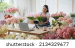 Small photo of Asia girl vlogger influencer or SME owner people smile work on home video camera selfie shoot filming for live sell show happy talk on mobile VoIP app. Remote sale product at modern florist gift shop.