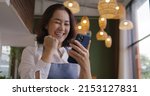 Small photo of Asia mature adult woman people wear apron small cafe receive e-mail text good news SME lending service solution win seller store in social media app. Shock smile laugh face in sale order reopen shop.