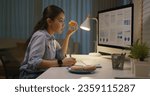 Small photo of Asia people young girl work busy at home office sit on desk crave sweet junk fast food eat bite donut at night. Workforce issue bad habit stress relief by fat diet break time late dinner in hard job.
