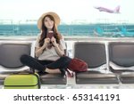 Cute asian student college traveler feeling happy action with travel plan and waiting for flight at airport terminal. Teenager travel concept