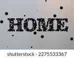 Small photo of A stipple of the word "Home" against a wall.