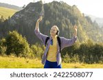 Small photo of Closeup portrait of a lovely young girl listening to music through wireless earphones on nature background. Music lover enjoying music. Woman in active trekking clothes having a halt after hiking.