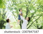 Small photo of Happy family image of a child and a couple happy to have their child do something high in the fresh greenery Upper half of the body Wide angle, inciting photo　