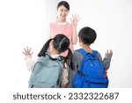 Small photo of A Japanese female teacher seeing a child off. Situations at school, cram school, and lessons.