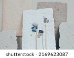 Small photo of Dried viola flower pressed onto a sheet of handmade paper with a pronounced explicit texture. Reuse of materials.