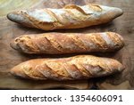 Three crunchy french baguettes on wood backgound
