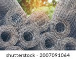 Small photo of Mesh wire rolls of iron stainless steel, galvanized metal sheets construction material. Chicken wire mesh rolls farm fence. Net wire mesh roll engineer Construction galvanize malleable steel storage