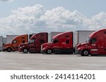Small photo of Somerset, Pennsylvania – July 23, 2023: Semi-trucks parked in lot at rest stop on the Pennsylvania Turnpike.