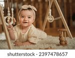 Small photo of Beneath a wooden baby gym, an infant explores textures and forms, guided by a parent. Showcases the nurturing role in child development.
