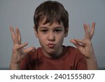 Small photo of Boy mimicking an animal with hands, puckered lips for effect. Captures a child's imaginative play and their connection with nature