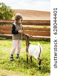 Little Girl Feeding Goat On...