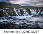 Scenic image of Iceland. Incredible nature landscape. Stunning view of Bruarfoss Waterfall. Azure water flows over stones. Bright midnight sun of Iceland. Iceland is a most popular place of travel.