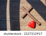 Small photo of Red heart, wooden Jesus cross on tile. Concept Jesus loves you, Jesus crucify himself with love. Forgiving sin, Easter time , Faith God. Christianity background, copy space.