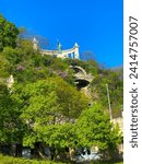 Small photo of Budapest, Hungary - April 2023: statue of St Gerard on Gellert hill with beautiful view of green trees taken from a low angle in summer