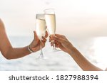 Hand holding a glass drinking wine on Sunset sea background.