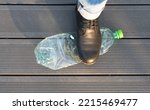 Small photo of Trample bottle by foot. Empty plastic bottle deformation, trampling garbage, pressing waste before throwing it away