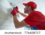 worker installing or adjusting motion sensor detector on the ceiling