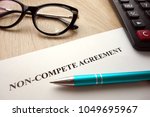 Non-compete agreement document for filling and signing on desk, business competition concept
