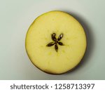 Small photo of Cut in two yellow red apple with white background