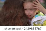 Small photo of little child cries, tears child face, mother calms capricious kid girl daughter, happy family, wipe tears face, hug kid park, children tears, shame, children hysteria, parental support, searching