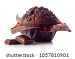 Chocolate muffin in brown paper with chocolate pieces isolated on white background