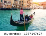 Venetian gondolier carries tourists on gondola Grand Canal of Venice, Italy