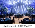 Small photo of Event decor with chic table setting with blue tablecloths and flowers. Scene in the background. Light filling.