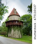 Small photo of Old Scandinavian Castle Citadel Tower named Kiiu Torn with wooden balcony and red roof behind the green trees. Used for liquor museum at nowadays in Estonia. Kiiu Vassal Stronghold, or the Kiiu Tower
