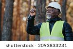 Small photo of Elderly forestry engineer professional shares experience assesses environment an foreman supervises felling of emergency trees old forester in protective helmet points finger shake head agree good job