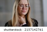 Small photo of Caucasian business woman girl in glasses worker manager holding throat indoors feels discomfort sore throat respiratory disease covid symptom panic attack suffocation lack of air suffering from asthma