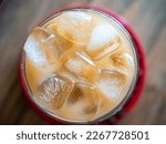 a cup of coffe filled with ice cubes,close up top shot. Refreshing summer drink.