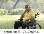 Small photo of Unhappy, Sad, Despondent despairing and senior amputee disabled old Man. Senior old man having anxiety symptoms sitting in a wheelchair pensively at summer park. Health treatment concept.
