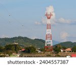 Small photo of High voltage power lines tower on green mountain, Red high Pylon high-voltage power lines, high voltage electric transmission tower for producing electricity at high voltage electricity poles