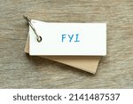 Small photo of Flash card with handwriting word FYI (Abbreviation of For your information) on wood background