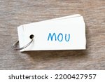 Small photo of Flash card with handwriting in word MOU (Abbreviation of memorandum of understanding) on wood background