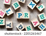 Small photo of Alphabet letter block in word PR (Abbreviation of purchase requisition or public relations) and another letter on wood background