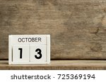 White block calendar present date 13 and month October on wood background