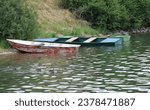 Small photo of The family of ducks swimming nearby the old colorful fishing boats at the reservoir Palcmanska Masa at the small slovakian village called Dedinky.