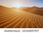 Sunset over the desert of Al Khatim in Abu Dhabi, Emirates. Golden Sand Dune Desert Landscape Panorama. Beautiful sunset over the sand dunes in the Al Khatim in Abu Dhabi, Emirates