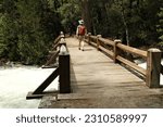 Man Walking Across Bridge over a River